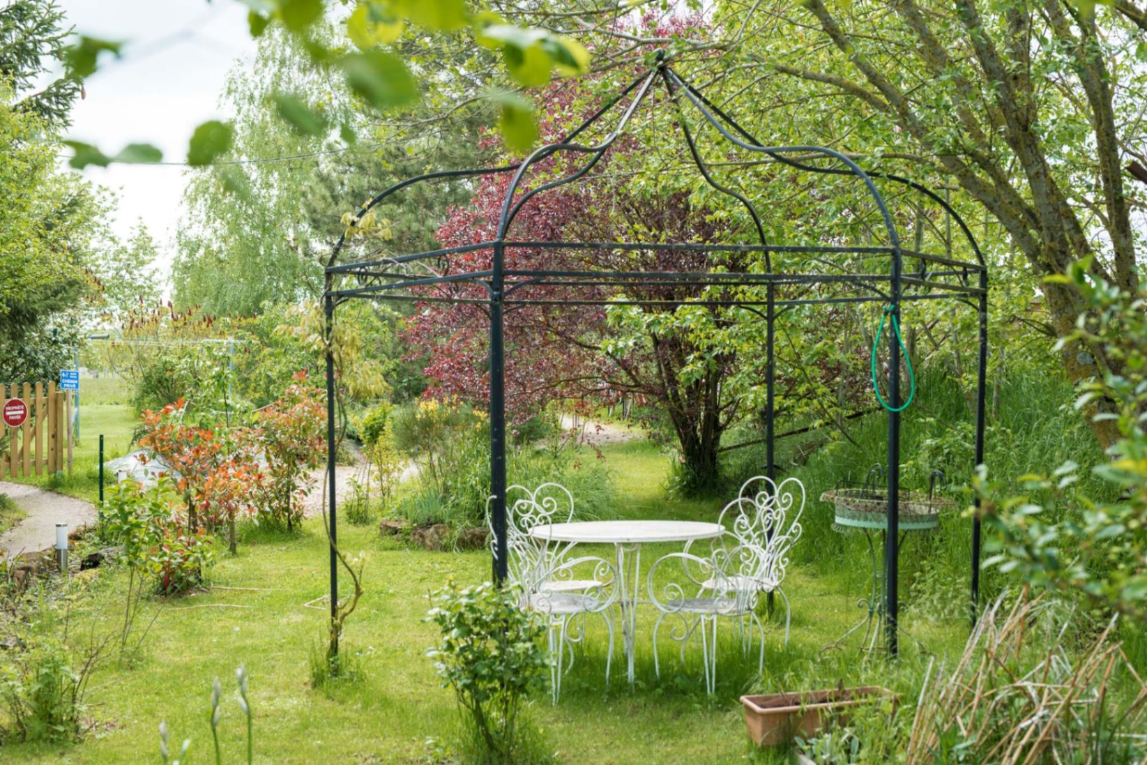 Kiosque en fer forgé dans un jardin paysager